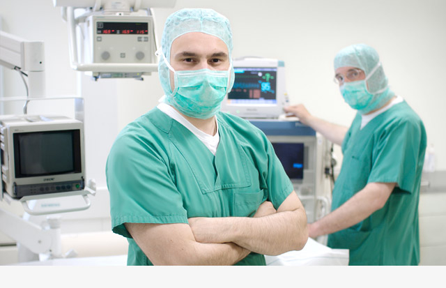 Dr. Schmid und Dr. Balangas in OP-Bekleidung im Operationssaal