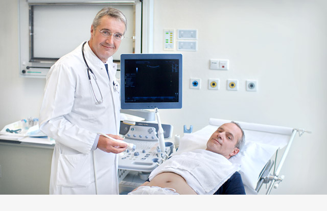 Dr. Hans Schmid mit Patient am Ultraschallgerät